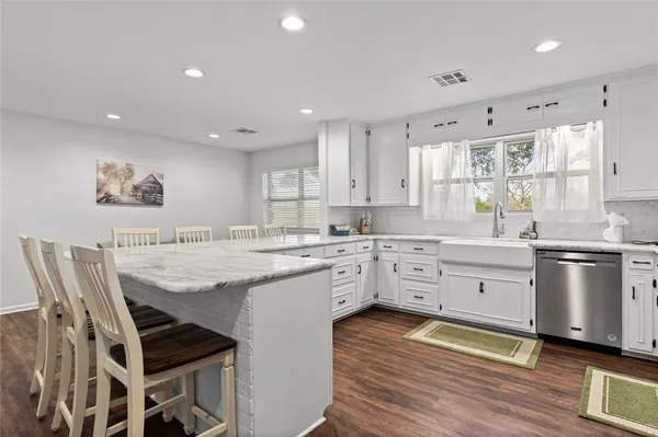 a kitchen with stainless steel appliances kitchen island granite countertop a sink and cabinets