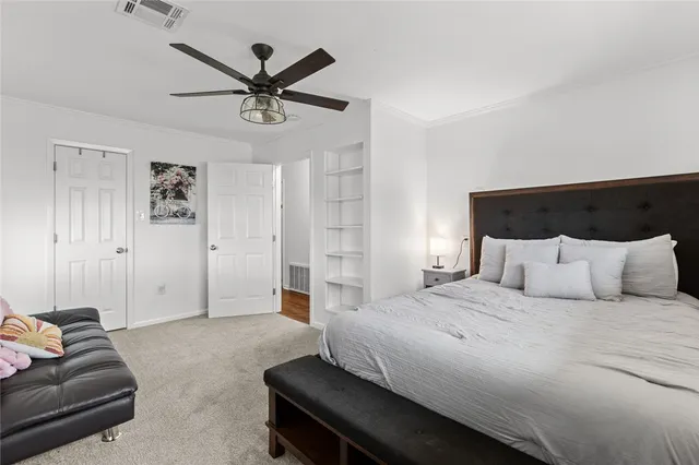 a spacious bedroom with a bed and ceiling fan