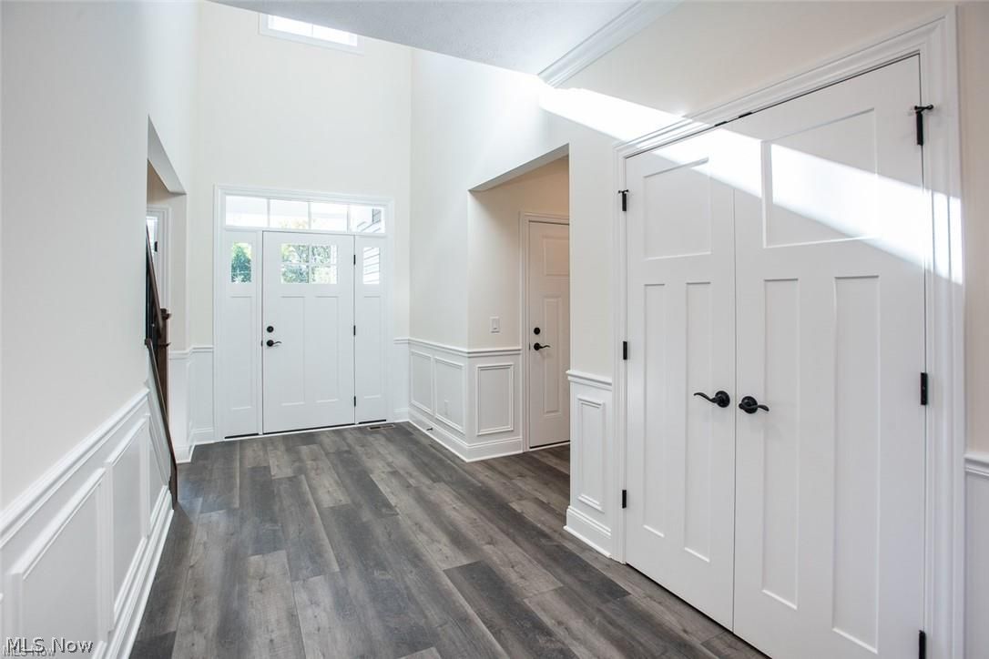 34286 Brookside Lane North Ridgeville, OH 44039 - Photo 6 of 50 Entryway featuring a decorative wall, dark wood-type flooring, a wainscoted wall, and a high ceiling