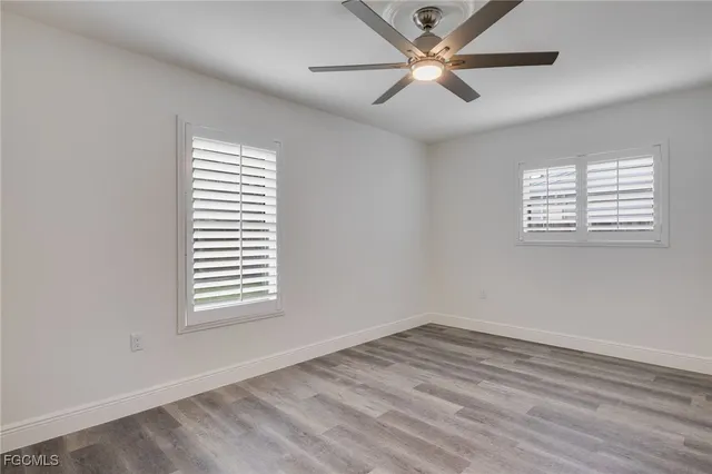 a view of an empty room with a window and a ceiling fan