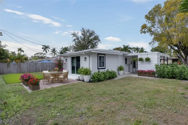 a view of a house with backyard and sitting area