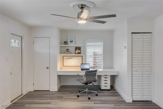 a view of a workspace with furniture and a window