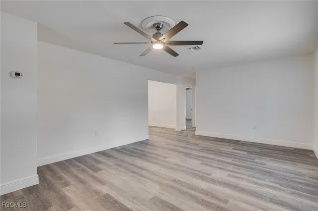 a view of a room with wooden floor and ceiling fan