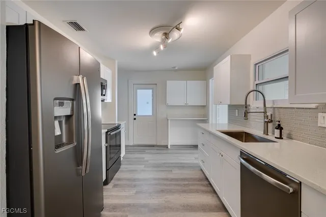 a kitchen with stainless steel appliances a sink stove and refrigerator