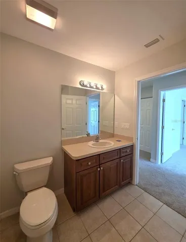 a bathroom with a granite countertop toilet a sink and a mirror