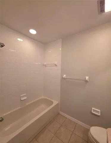 a bathroom with a granite countertop bathtub shower and toilet