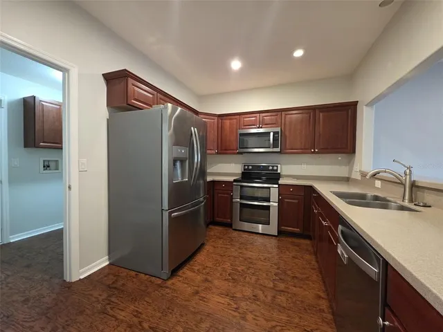 a kitchen with stainless steel appliances granite countertop a refrigerator stove and sink