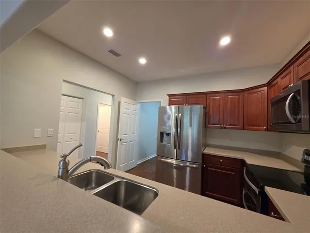 a kitchen with stainless steel appliances granite countertop a sink and a refrigerator