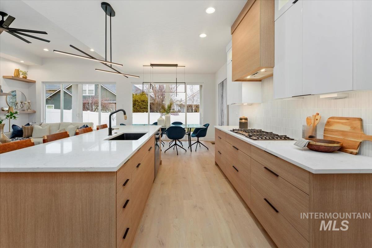 6248 West Elmer Street Boise, ID 83703 - Photo 31 of 40 Kitchen with modern cabinets, white cabinets, light stone counters, pendant lighting, and light wood-type flooring