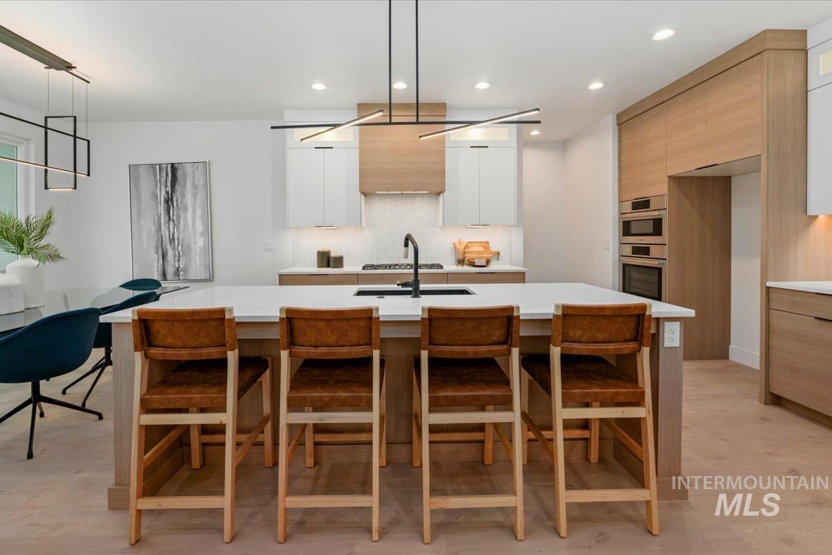 6248 West Elmer Street Boise, ID 83703 - Photo 33 of 40 Kitchen with decorative light fixtures, a breakfast bar, modern cabinets, recessed lighting, and an island with sink