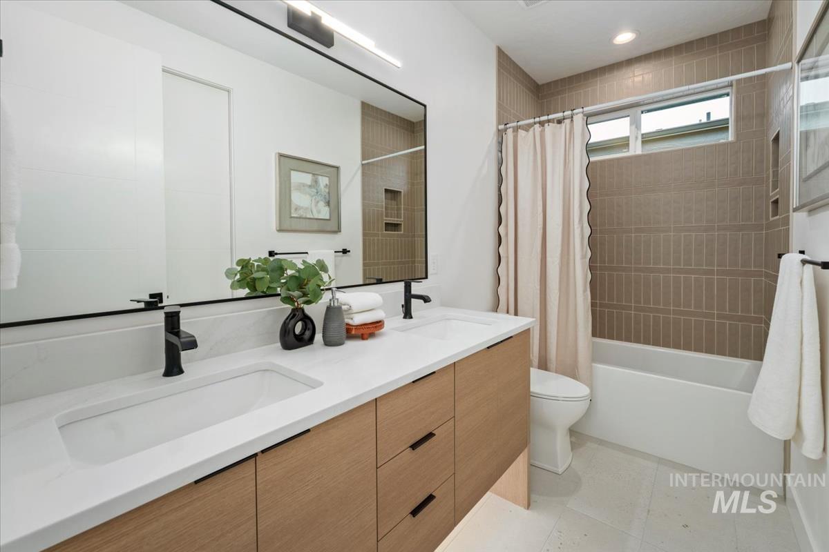 6248 West Elmer Street Boise, ID 83703 - Photo 5 of 40 Bathroom featuring double vanity, shower / bathtub combination with curtain, and light tile patterned floors