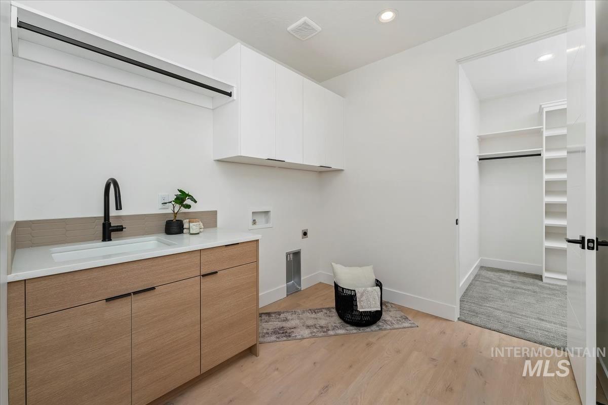 6248 West Elmer Street Boise, ID 83703 - Photo 8 of 40 Laundry area with light wood finished floors, recessed lighting, washer hookup, cabinet space, and electric dryer hookup