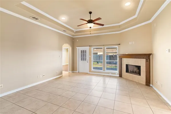 a view of an empty room with a fireplace and a window