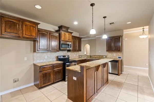 a kitchen with stainless steel appliances granite countertop a stove a sink and a refrigerator