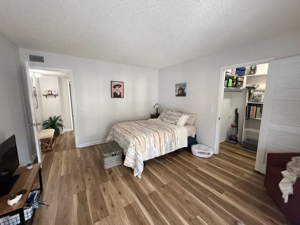 a bedroom with a bed and wooden floor