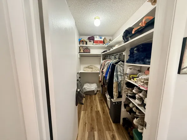 a view of walk in closet with clothes and shoes