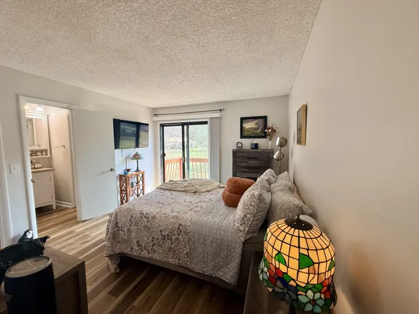 a bedroom with a bed and a flat tv screen on dresser