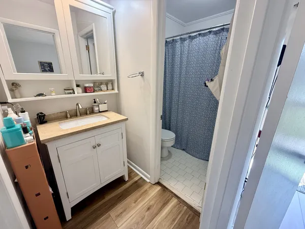 a bathroom with a sink a toilet a mirror and shower