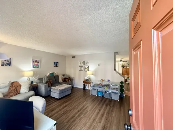 a living room with furniture and a wooden floor