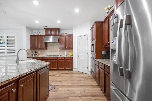 a spacious bedroom with a bed a dresser and a chandelier