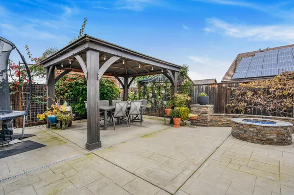 a patio with a table and chairs and potted plants