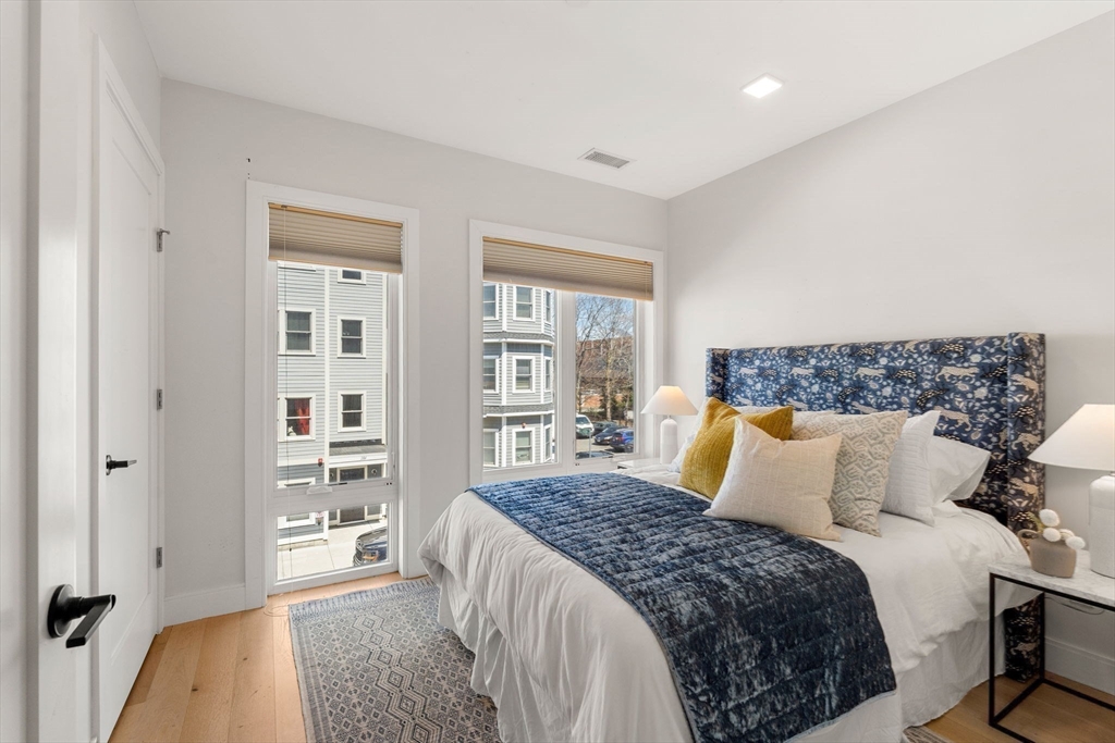 287 Maverick Street, Unit 201 Boston, MA 02128 - Photo 11 of 17 a bedroom with a large bed and a couch