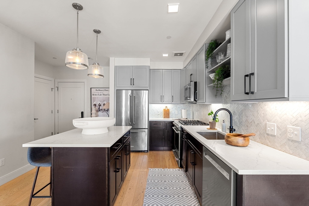 287 Maverick Street, Unit 201 Boston, MA 02128 - Photo 2 of 17 a kitchen with a sink stove and refrigerator