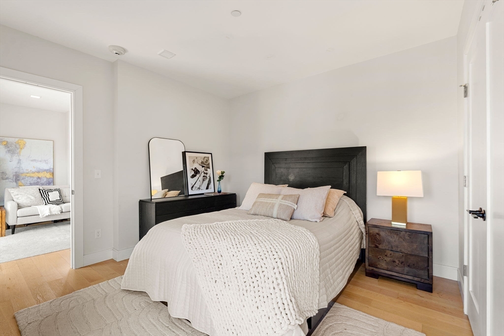 287 Maverick Street, Unit 201 Boston, MA 02128 - Photo 7 of 17 a bedroom with a bed and large mirror