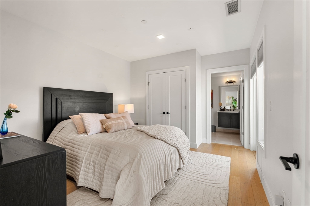 287 Maverick Street, Unit 201 Boston, MA 02128 - Photo 8 of 17 a bedroom with a bed and a walk in closet