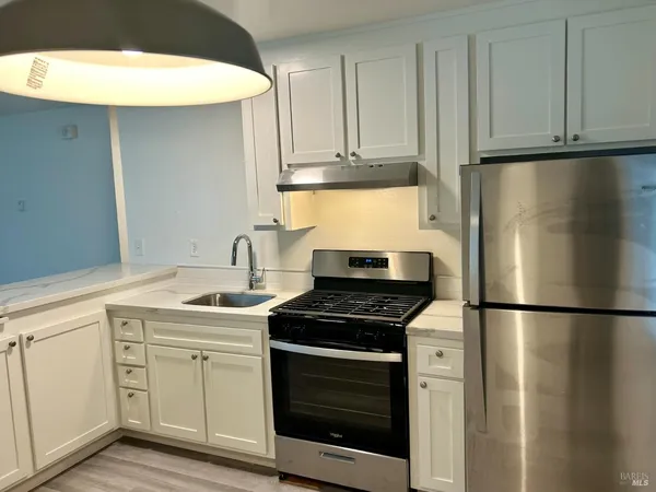 a kitchen with appliances cabinets and a counter top space