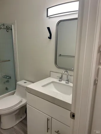 a bathroom with a granite countertop toilet sink and mirror