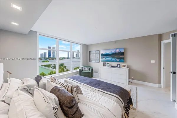 a bedroom with a bed and a large window