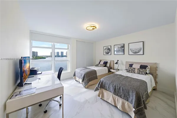 a bedroom with two beds and a desk