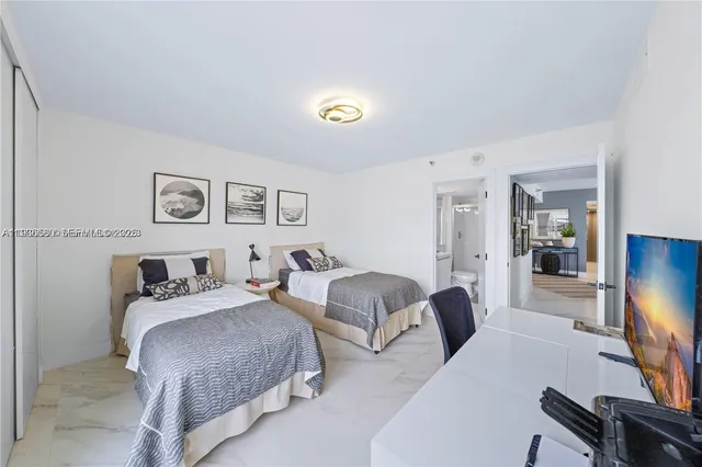 a bedroom with two beds and a flat screen tv