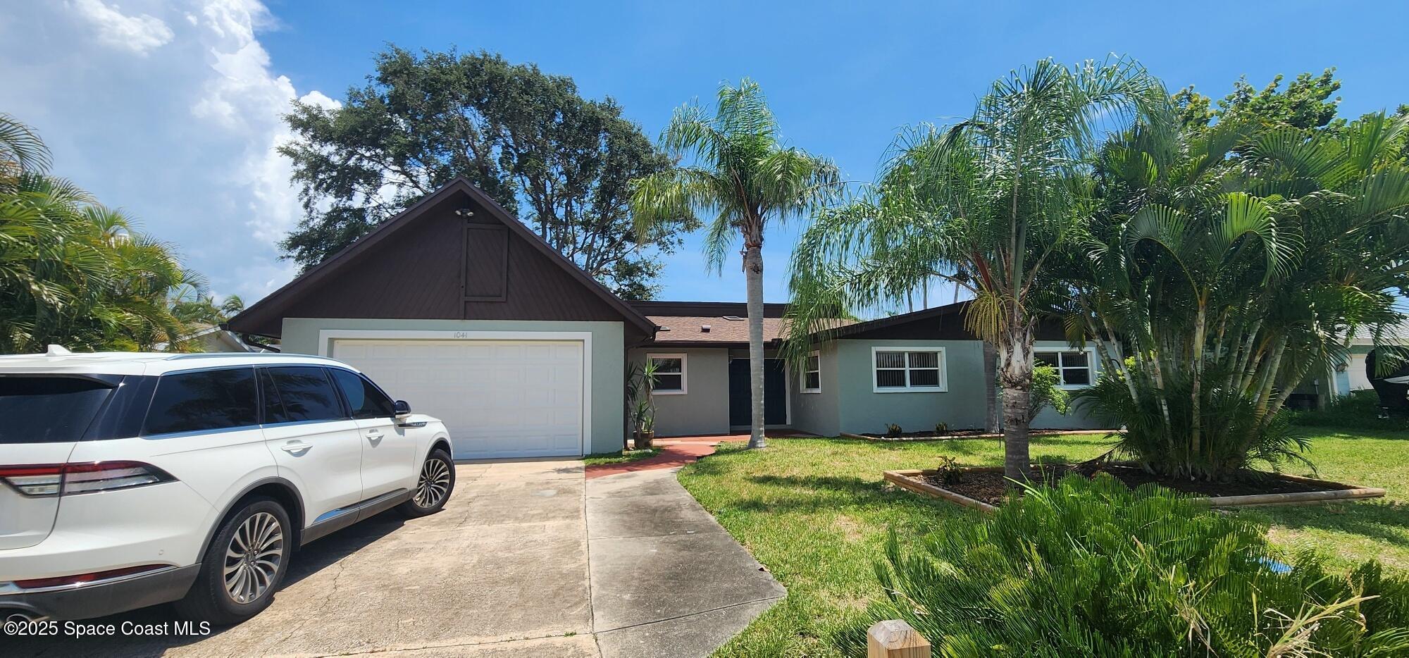 a front view of a house with a garden