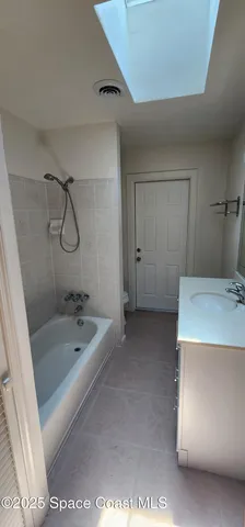a bathroom with a granite countertop sink a toilet and bathtub