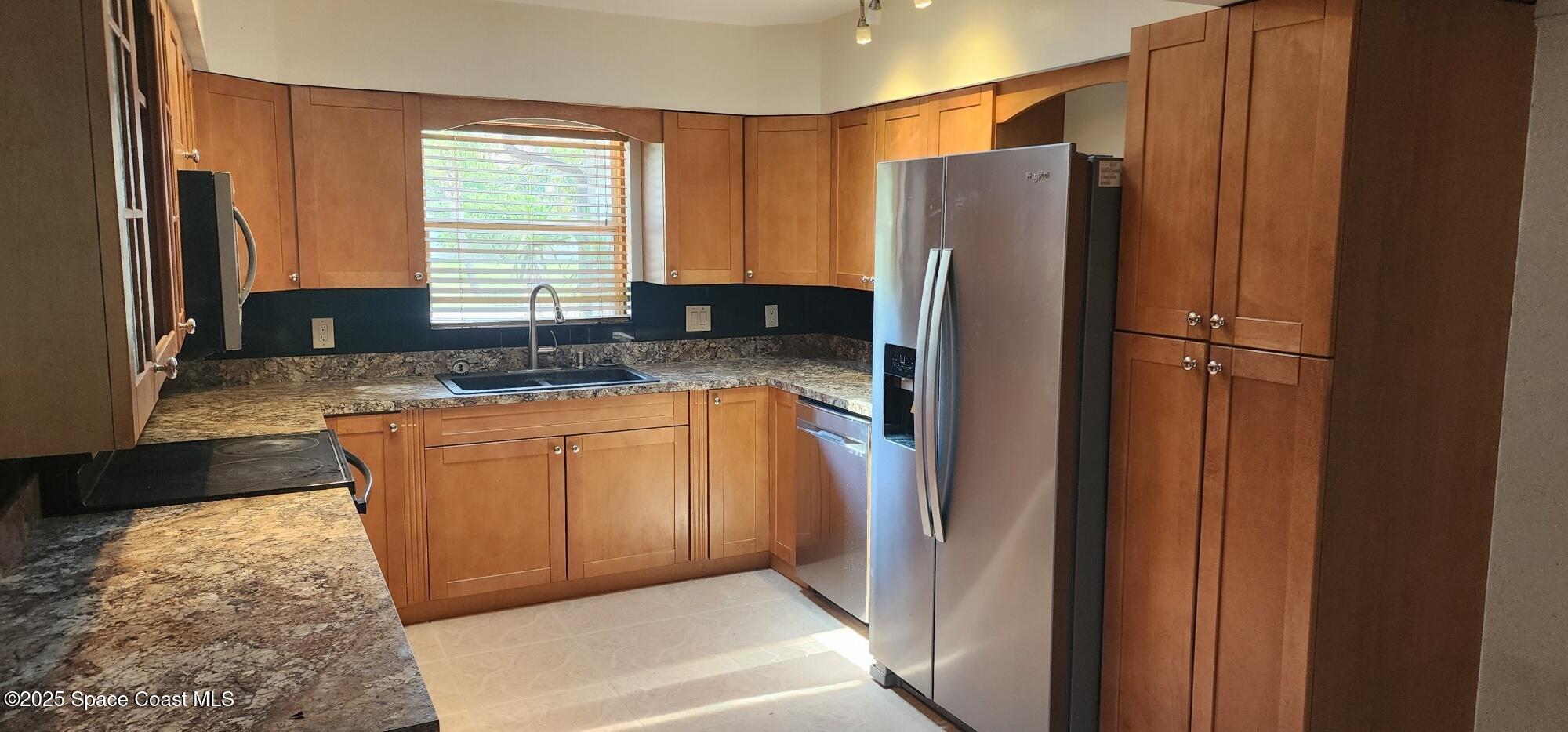 1041 Bali Road Cocoa Beach, FL 32931 - Photo 4 of 23 a kitchen with granite countertop cabinets and refrigerator