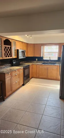a kitchen with stainless steel appliances a sink stove and white cabinets