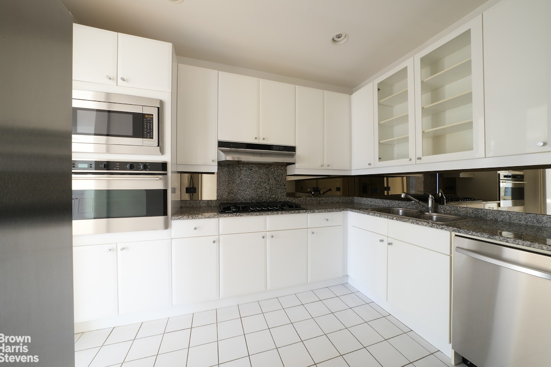 845 United Nations Plaza, Unit 33D Manhattan, NY 10017 - Photo 5 of 11 a kitchen with stainless steel appliances granite countertop a sink and a stove