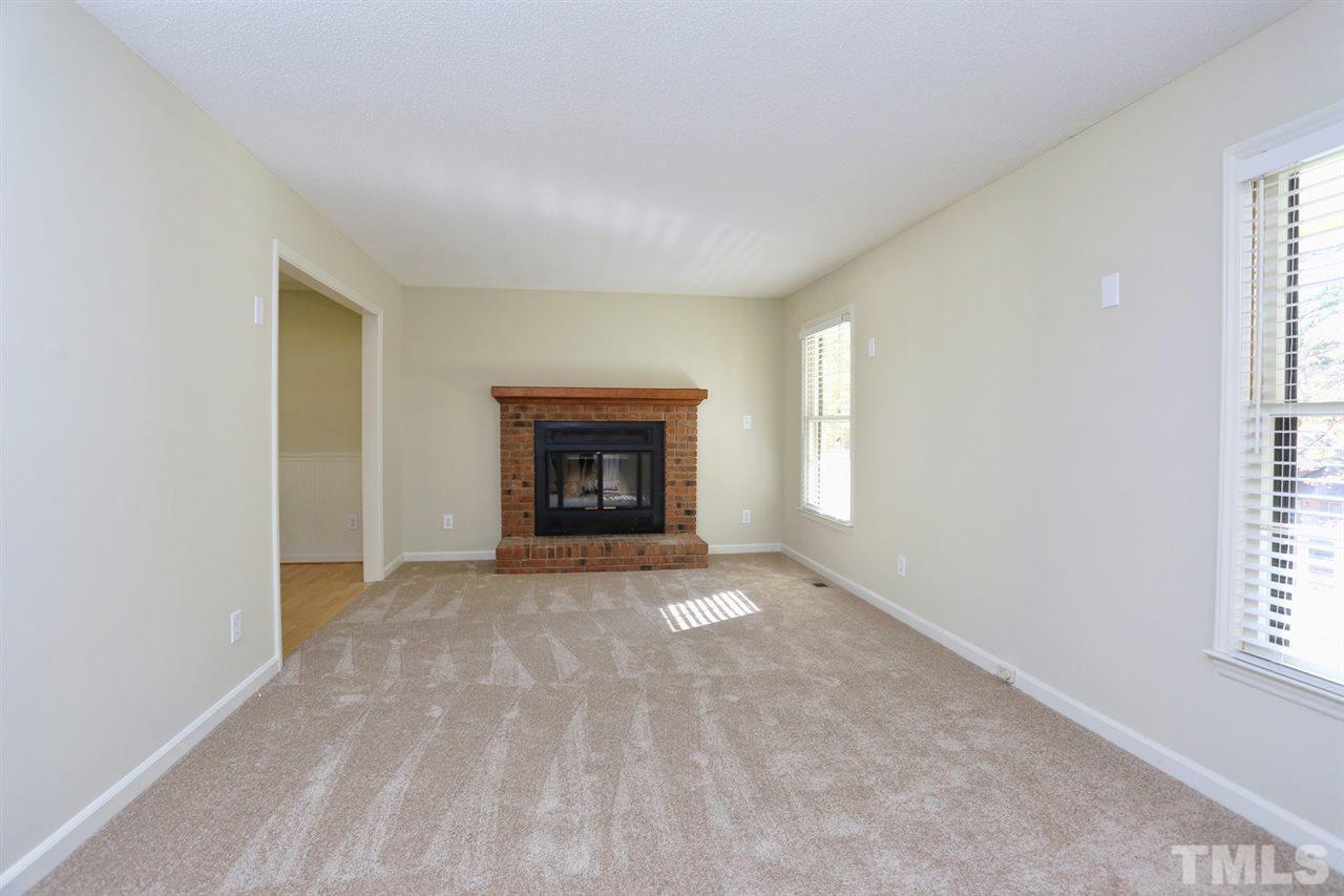 1124 Toppe Ridge Court Raleigh, NC 27615 - Photo 6 of 25 an empty room with windows and fireplace