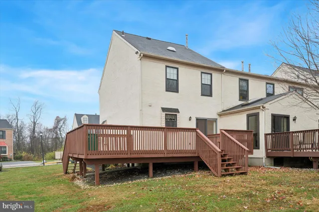 a view of a house with a wooden deck and a yard