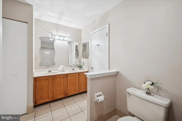 a bathroom with a granite countertop sink mirror and toilet