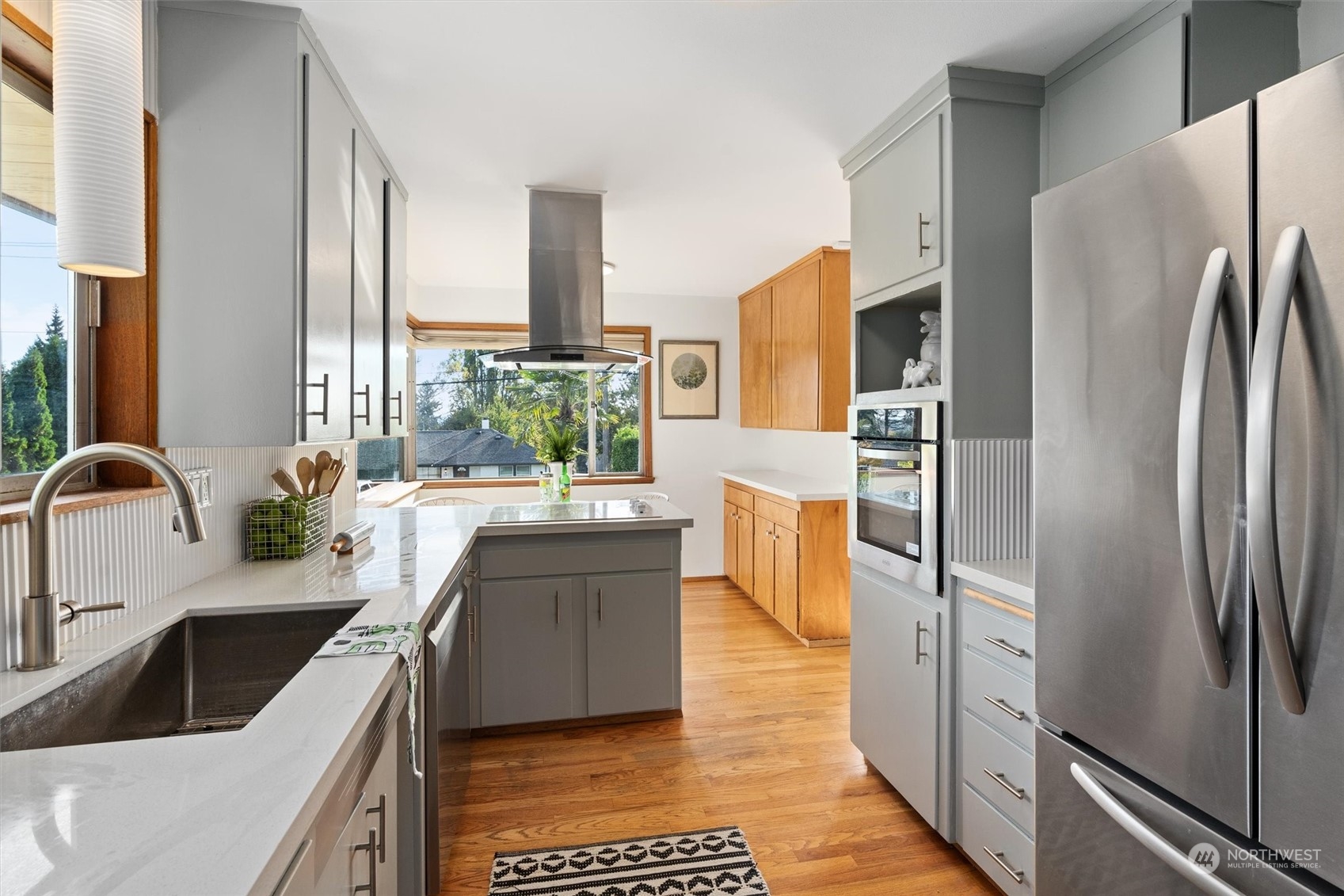 3616 Southwest 112th Street Seattle, WA 98146 - Photo 10 of 40 a kitchen with stainless steel appliances granite countertop a refrigerator a stove and a sink with wooden floor