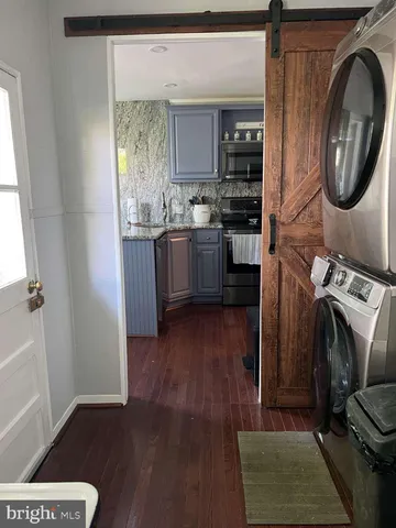 a kitchen with stainless steel appliances granite countertop wooden floors a stove and a window