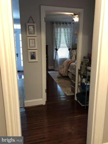 a view of a hallway with wooden floor and furniture