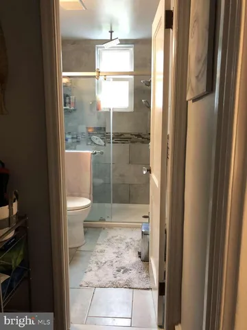 a bathroom with a granite countertop bathtub shower and toilet