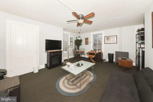 a living room with furniture a flat screen tv and a window