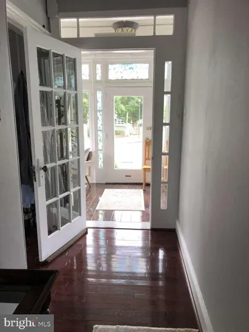 a view of a hallway with wooden floor and dining room view