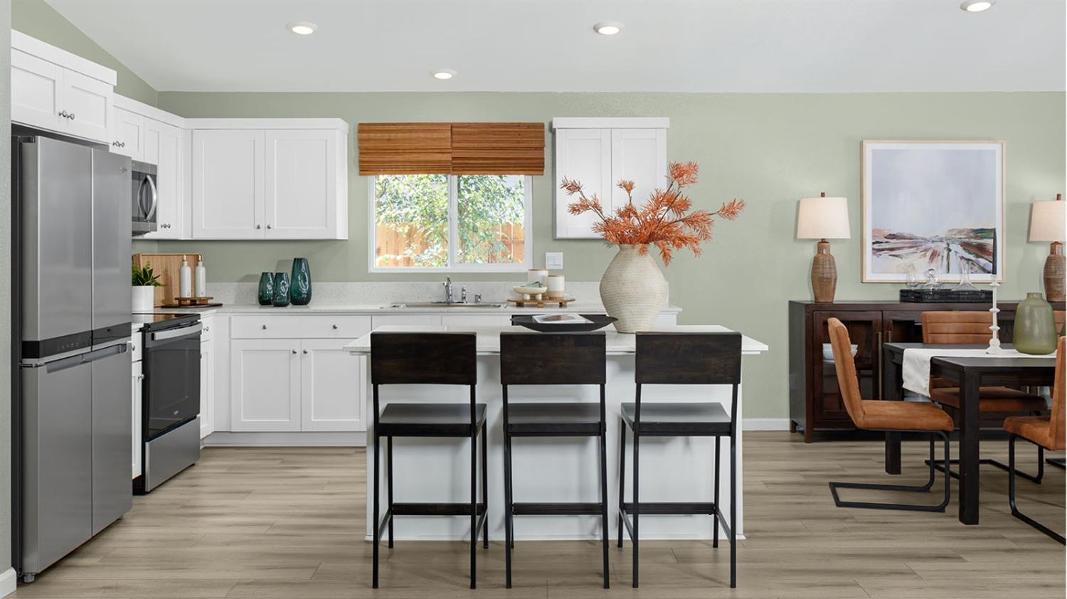 2483 Labrusca Street Manteca, CA 95337 - Photo 5 of 6 a kitchen with stainless steel appliances kitchen island granite countertop a table chairs microwave and sink