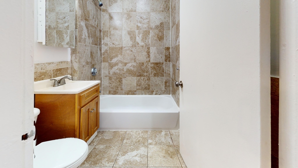 249 Washington Street, Unit 1 Boston, MA 02121 - Photo 3 of 8 a bathroom with a sink a toilet and bathtub